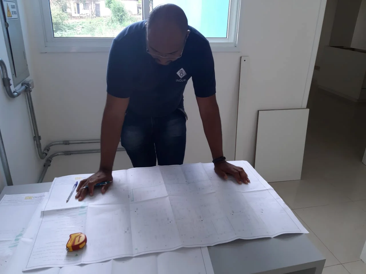 Especialista da INOUS analisando planta técnica de projeto